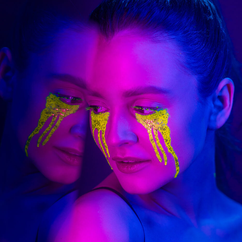 Neon-lit face with blue and pink lighting